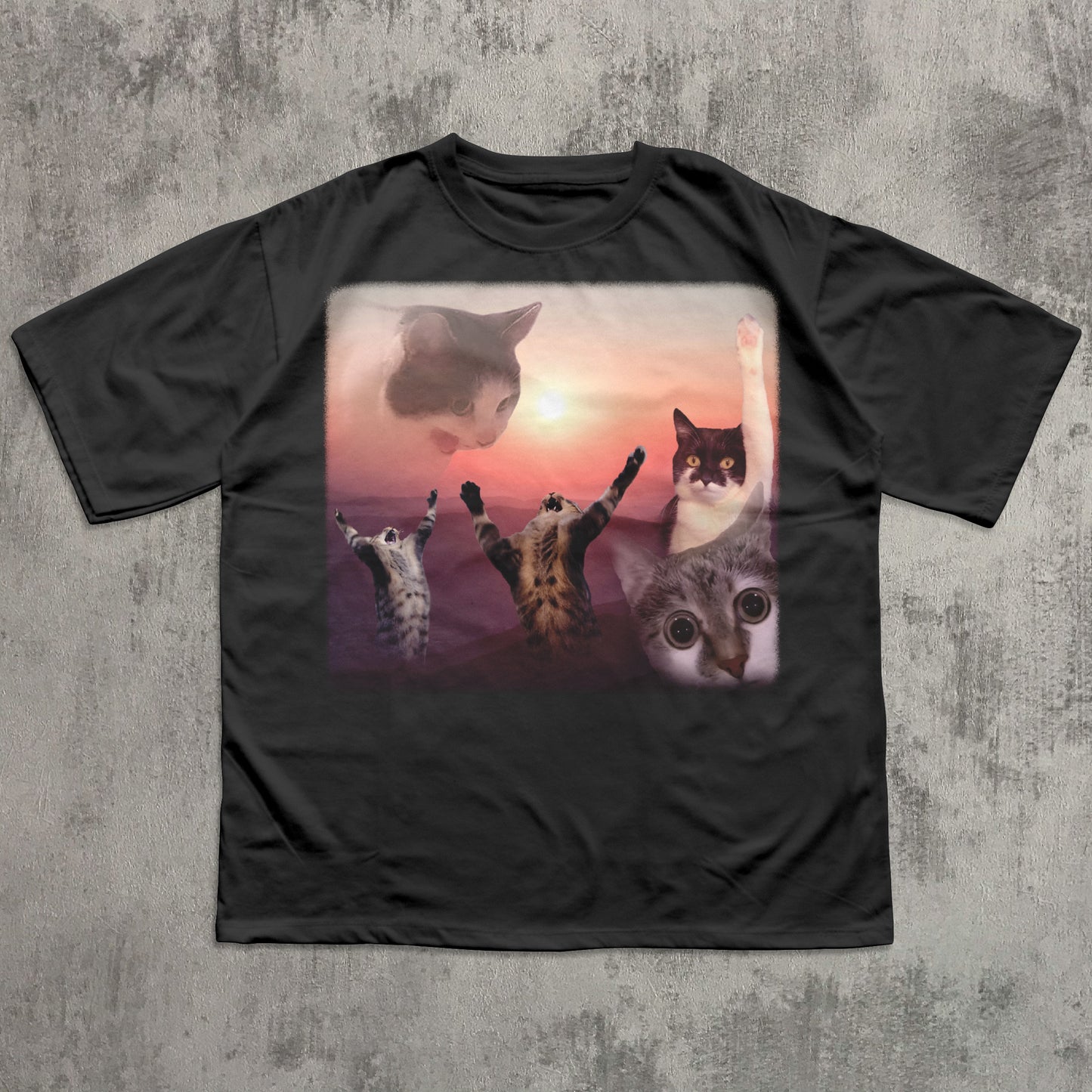 Black t-shirt with a graphic of cats at sunset on a textured gray background