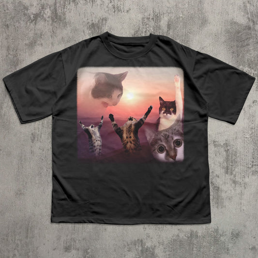 Black t-shirt with a graphic of cats at sunset on a textured gray background