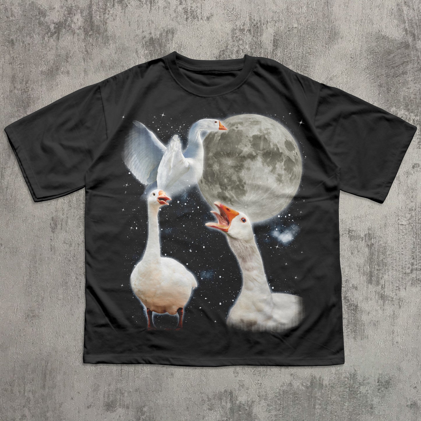 Black t-shirt with a graphic of three geese and a moon on a concrete surface