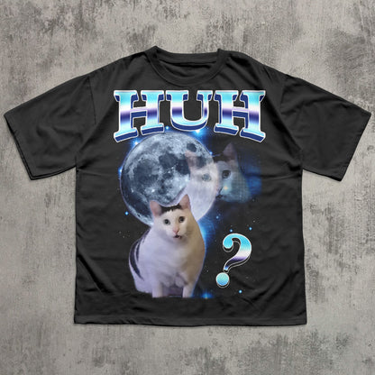 Black t-shirt with a cat graphic and 'HUH?' text on a textured gray background