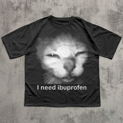 Black t-shirt with a graphic of a cat and text 'I need ibuprofen' on a textured gray background