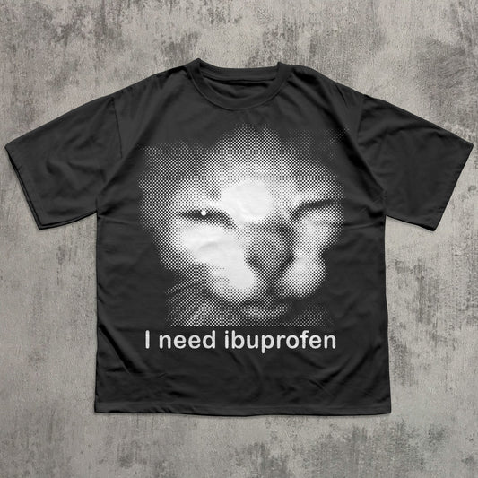 Black t-shirt with a graphic of a cat and text 'I need ibuprofen' on a textured gray background