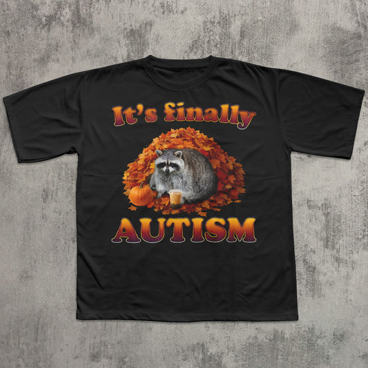 Black t-shirt with a raccoon graphic and 'It's finally AUTISM' text on a textured gray background