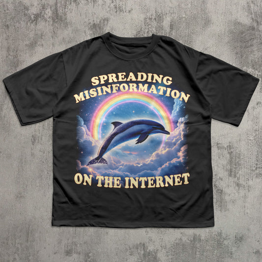 Black t-shirt with a dolphin and rainbow graphic and text on a concrete background