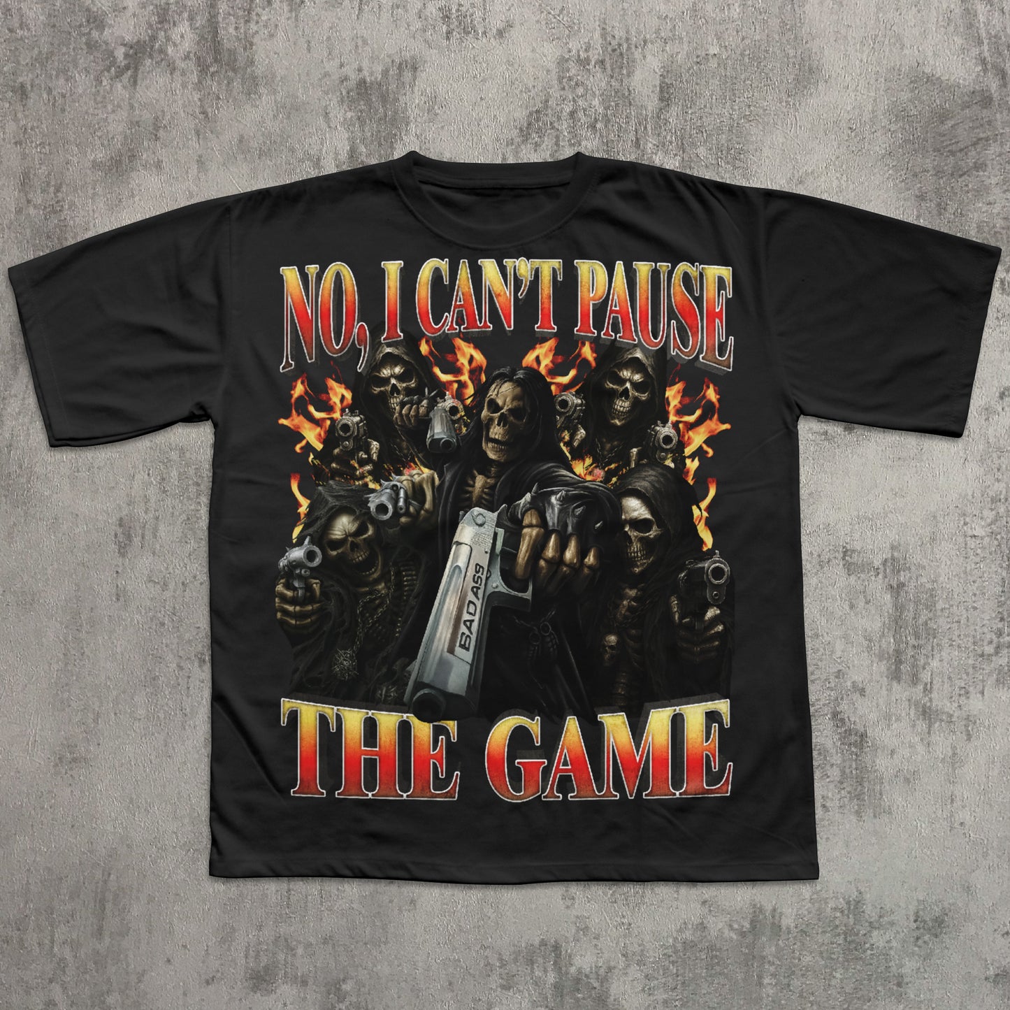 black t-shirt with graphic design of skeletons holding guns and a console, text 'No, I Can't Pause The Game' on a textured gray background.
