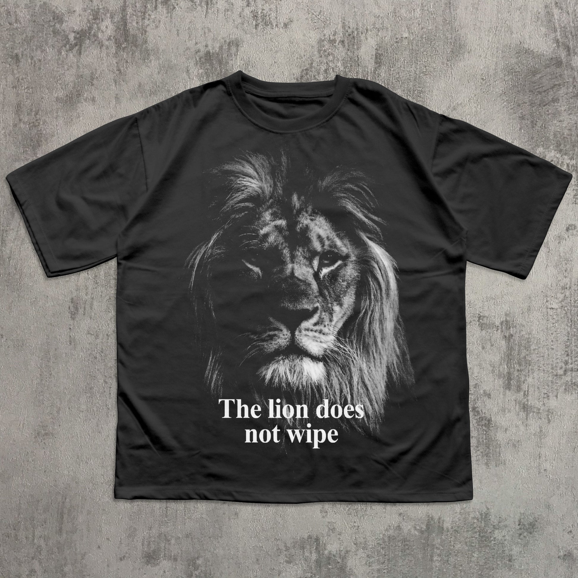 Black t-shirt with a lion graphic and text 'The lion does not wipe' on a textured gray background