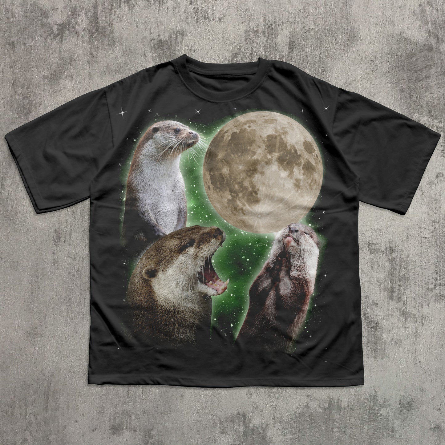 Black t-shirt with otter and moon design on a textured gray background