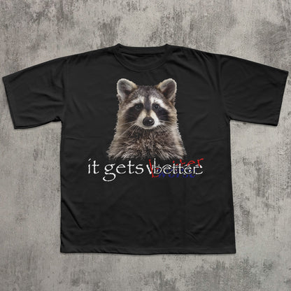 Black t-shirt with a raccoon graphic and text 'it gets better' on a textured gray background