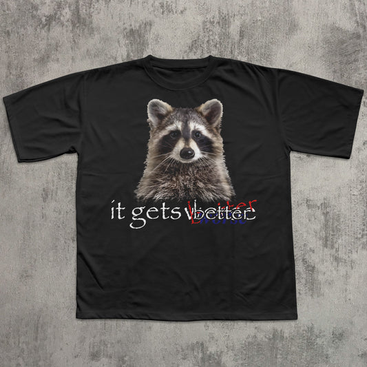Black t-shirt with a raccoon graphic and text 'it gets better' on a textured gray background