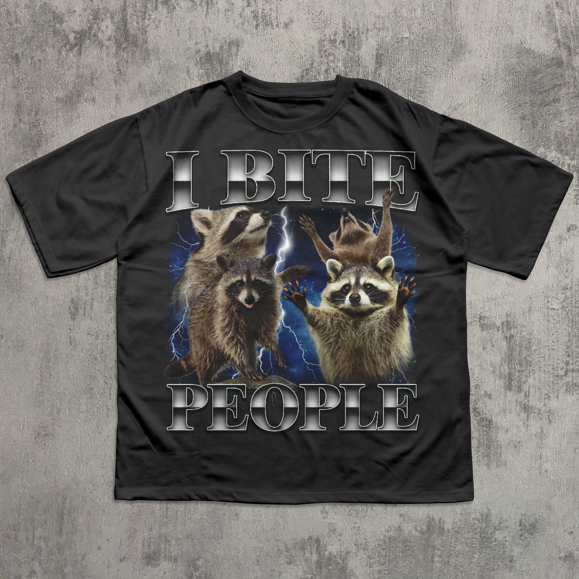 Black t-shirt with raccoon graphic and text 'I BITE PEOPLE' on a textured gray background