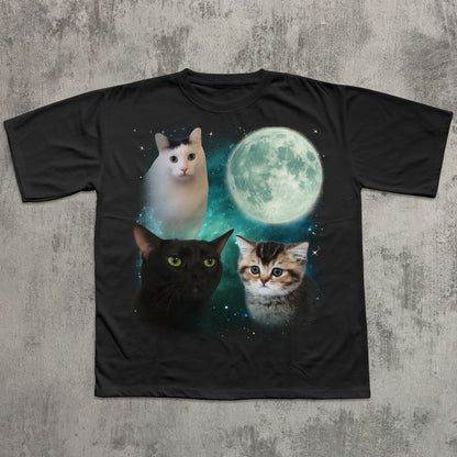 Black t-shirt with cats and a moon graphic on a textured gray background
