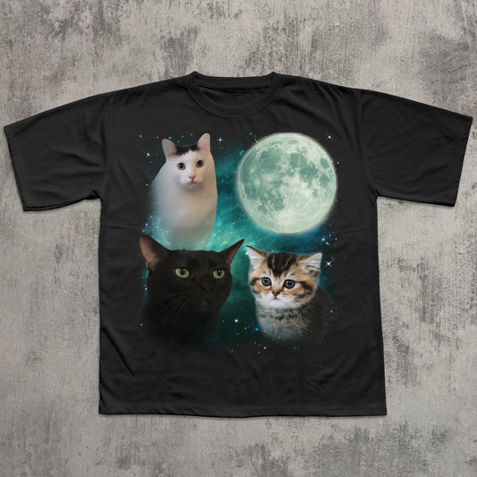Black t-shirt with cats and a moon graphic on a textured gray background