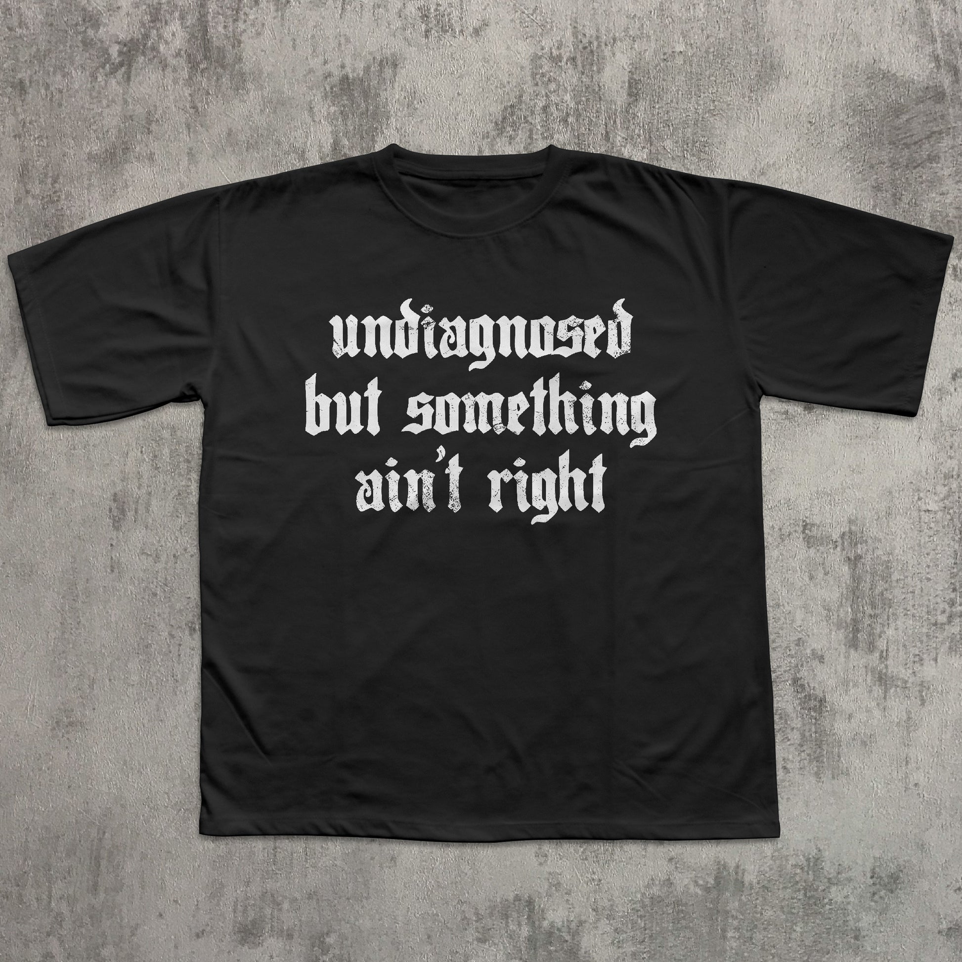 Black t-shirt with white text on a textured gray background