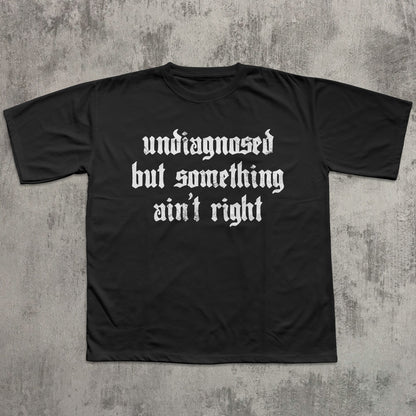 Black t-shirt with white text on a textured gray background