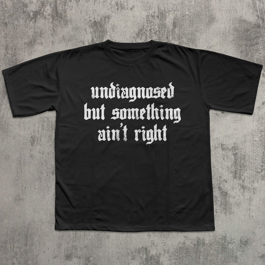 Black t-shirt with white text on a textured gray background