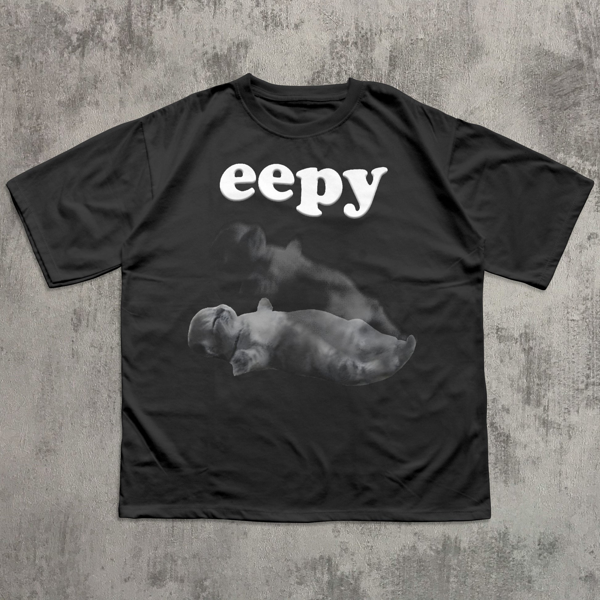Black t-shirt with 'eepy' text and cat graphic on a textured gray background