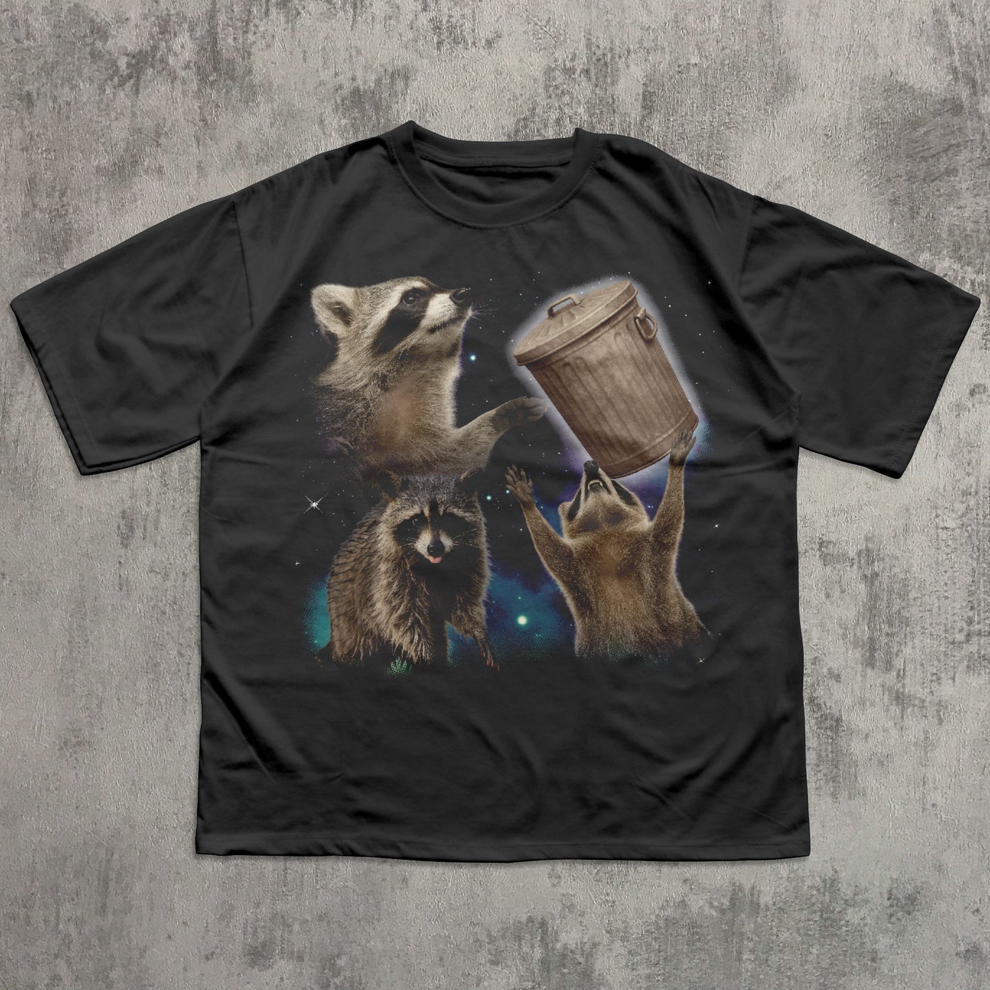 Black funny t-shirt with raccoon graphic on a textured gray background