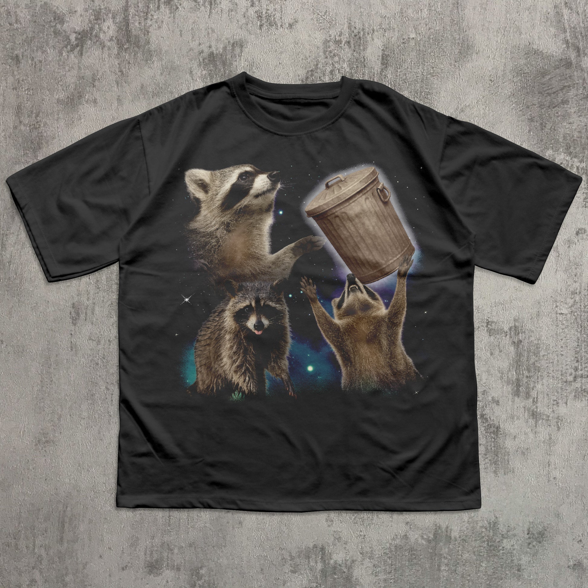 Black funny t-shirt with raccoon graphic on a textured gray background