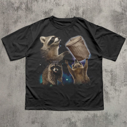 Black funny t-shirt with raccoon graphic on a textured gray background