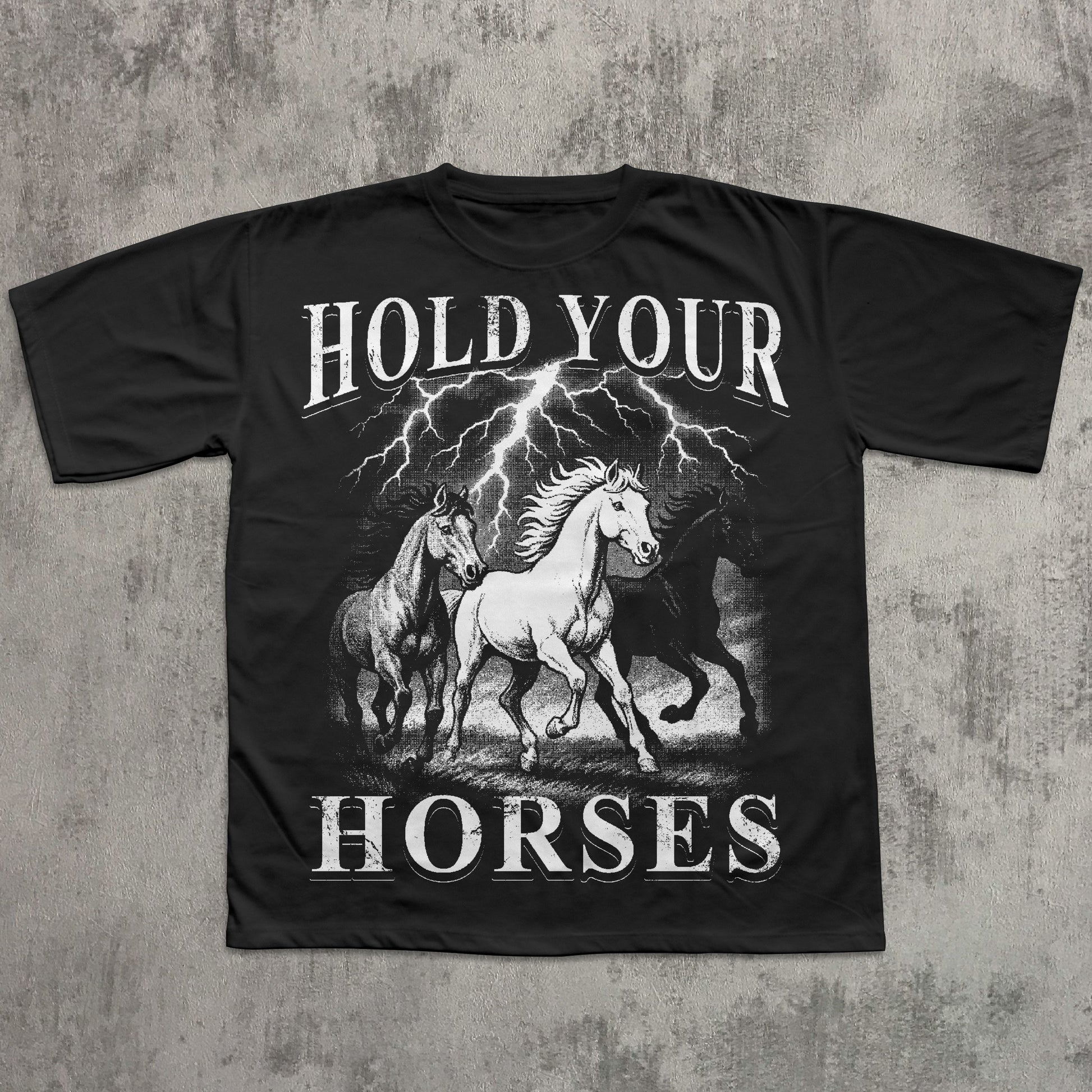 Black t-shirt with 'Hold Your Horses' graphic design on a textured gray background