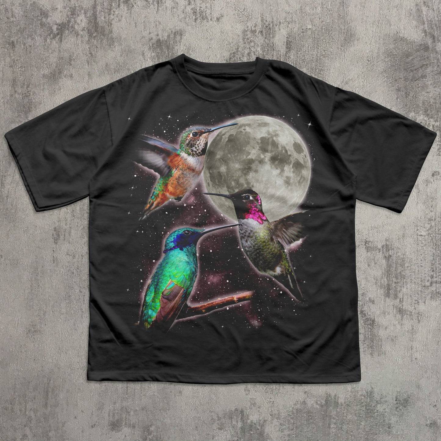 Black t-shirt with colorful hummingbird design and moon on a textured gray background