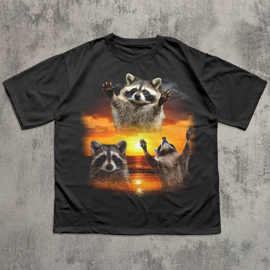 Black t-shirt with raccoon design on a textured gray background
