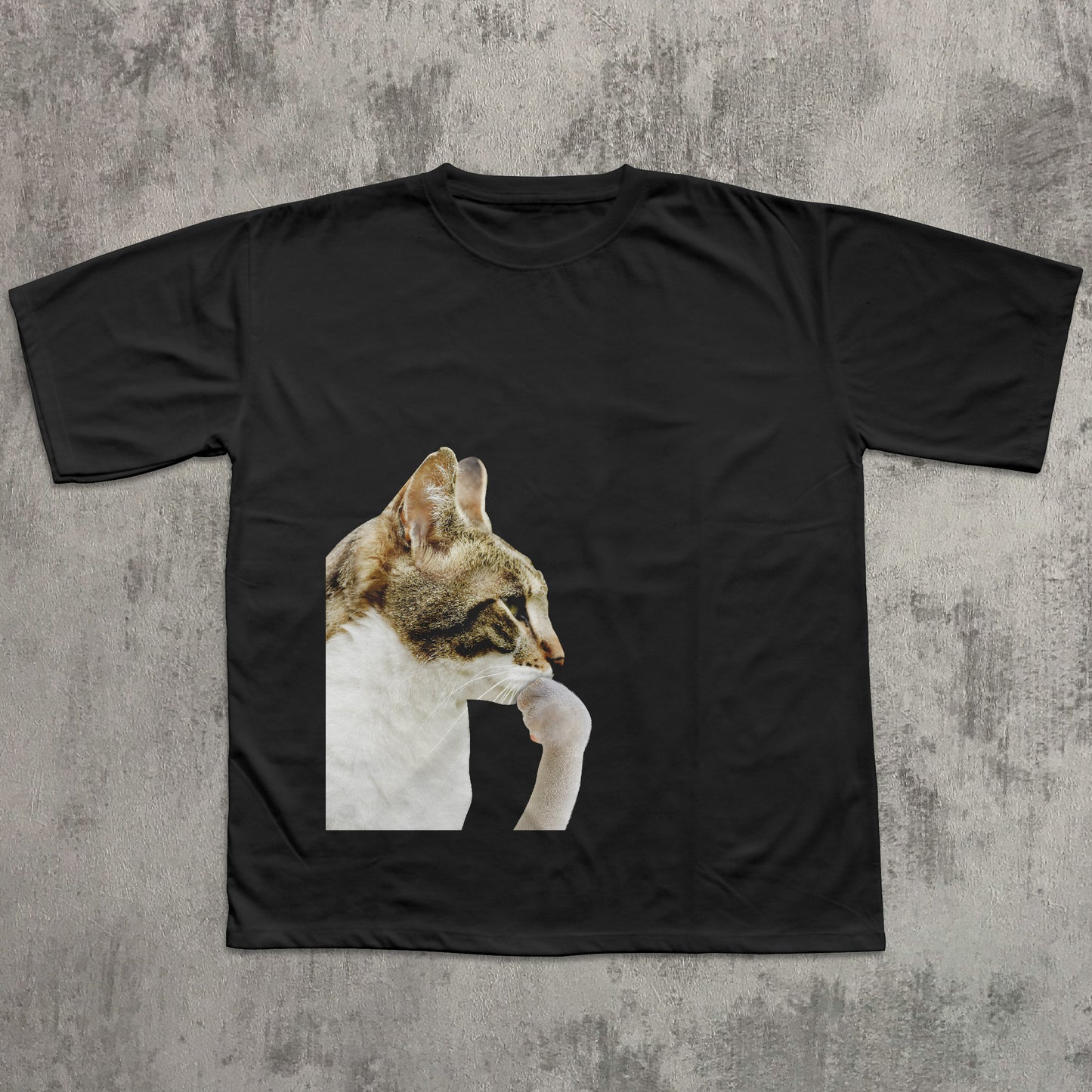 Black t-shirt with a cat graphic on a textured gray background