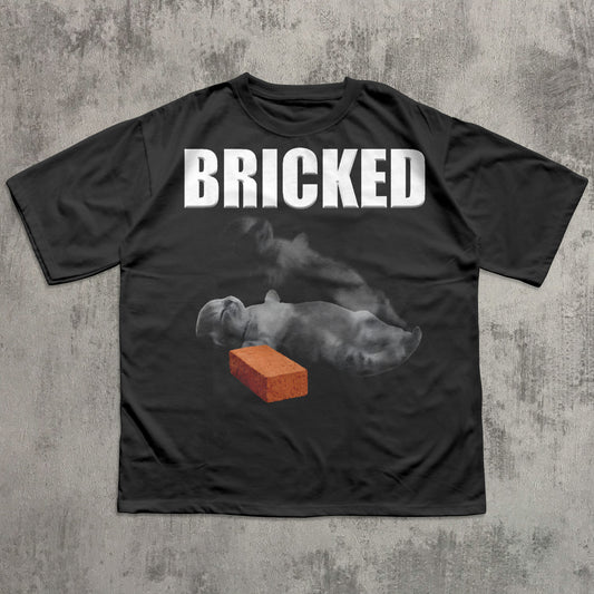 Black t-shirt with 'BRICKED' text and graphic of a Cat with a brick on a concrete background