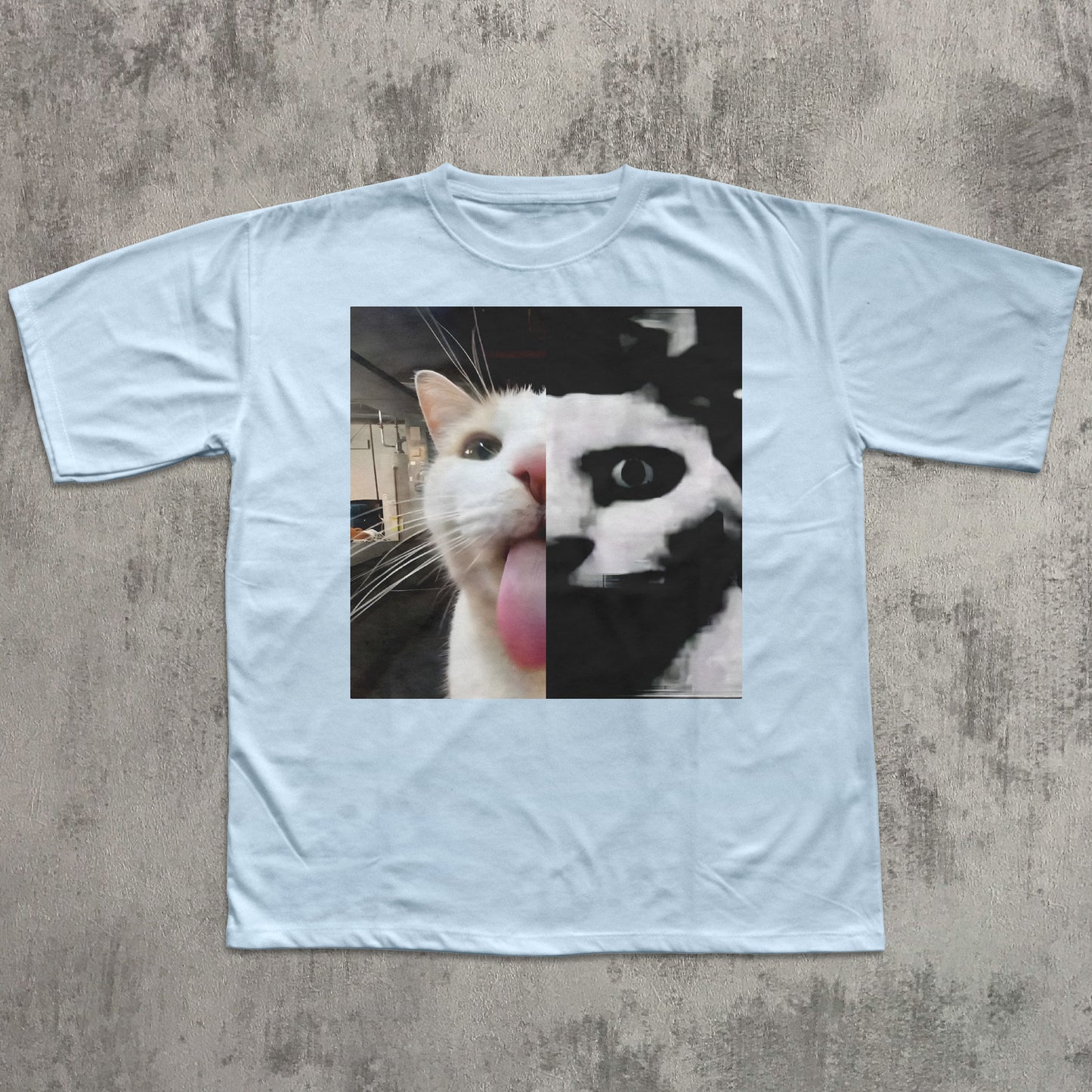 Light blue t-shirt with a graphic of a cat on a concrete surface