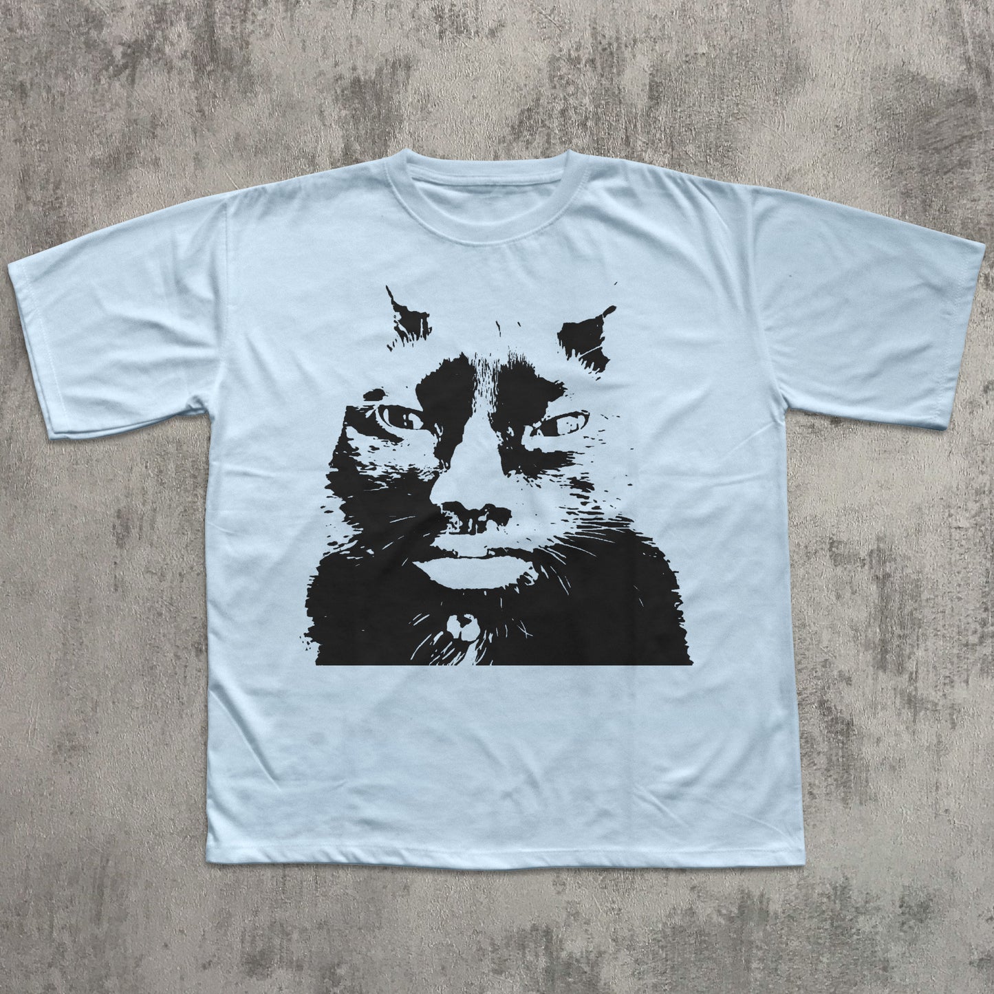 Light blue t-shirt with a black cat graphic on a textured gray surface