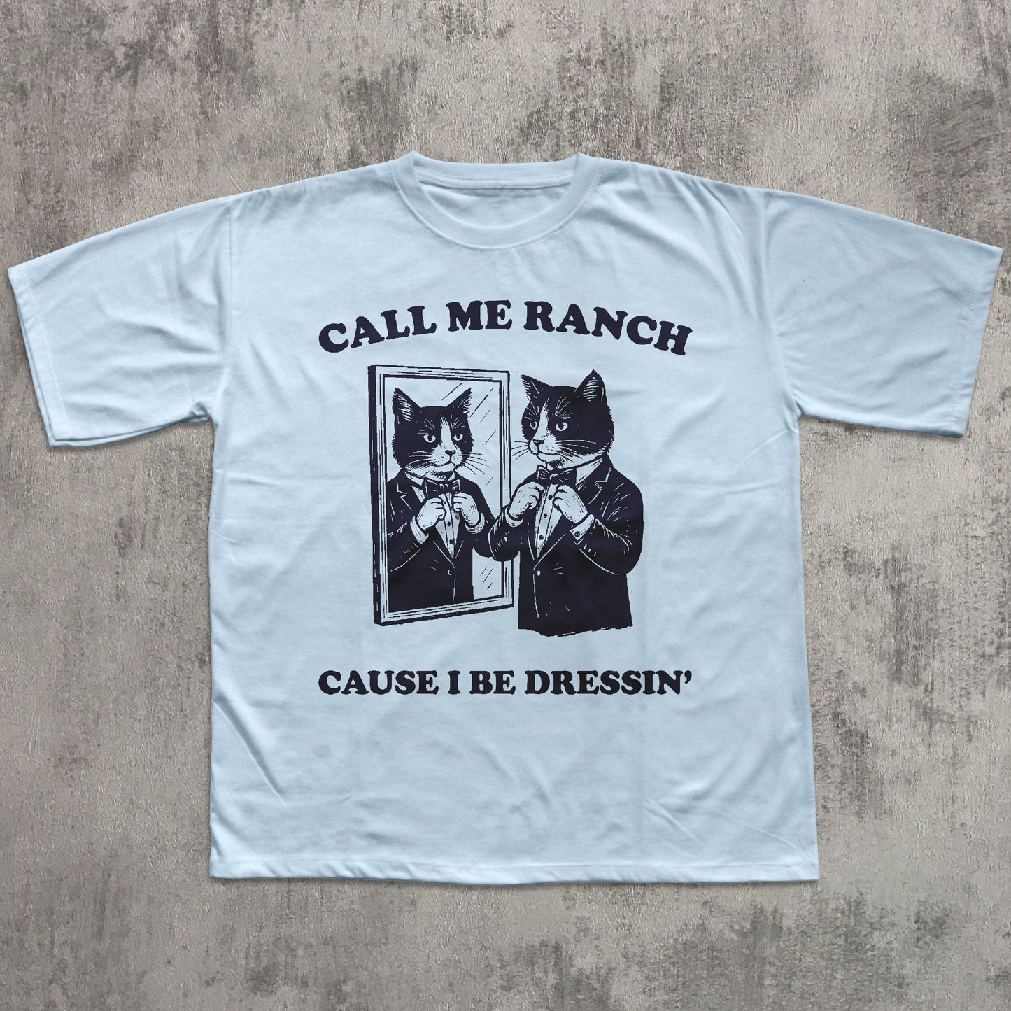 Light blue t-shirt with black graphic and text on a textured gray background