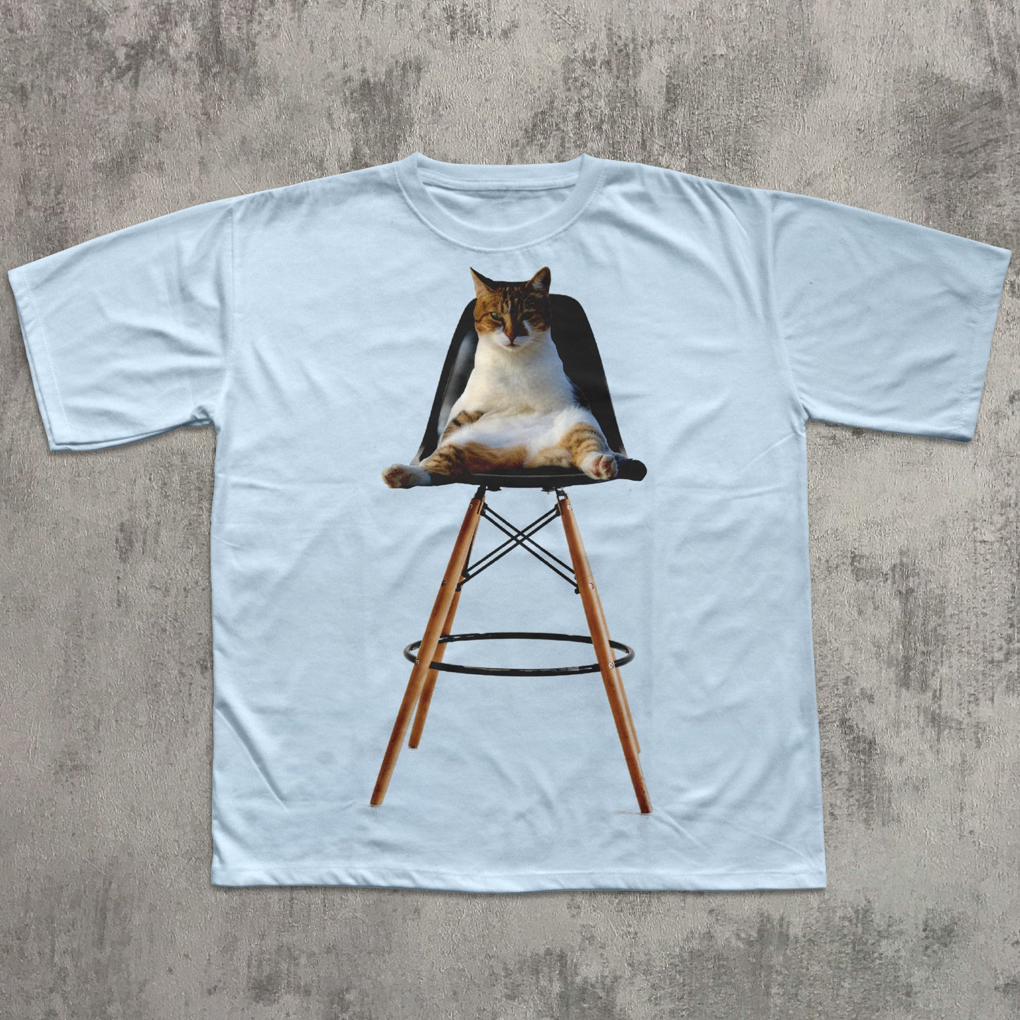 White t-shirt with a graphic of a cat sitting on a chair on a concrete surface