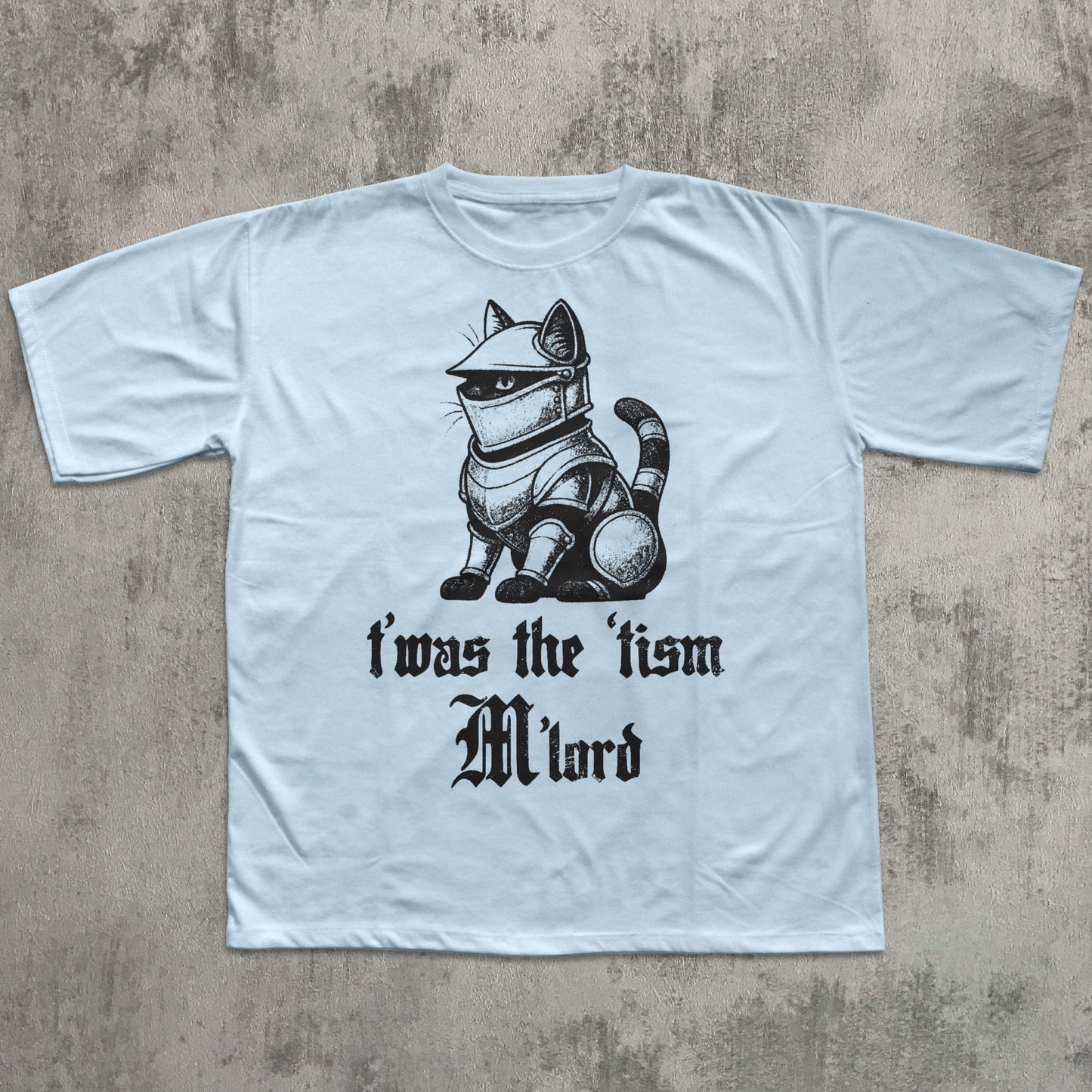 Light blue t-shirt with a cat in armor graphic and text on a concrete surface