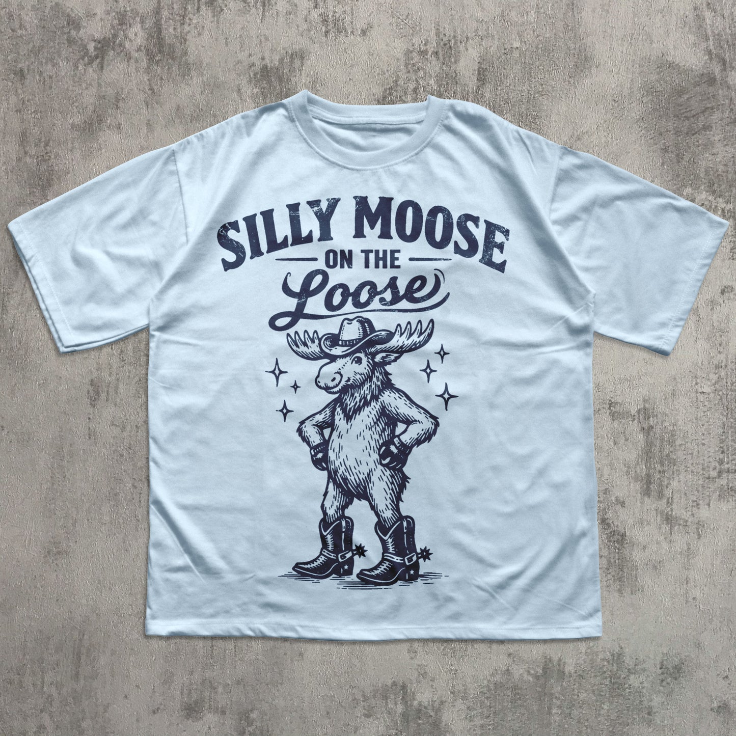 White t-shirt with 'Silly Moose on the Loose' graphic and text on a textured surface