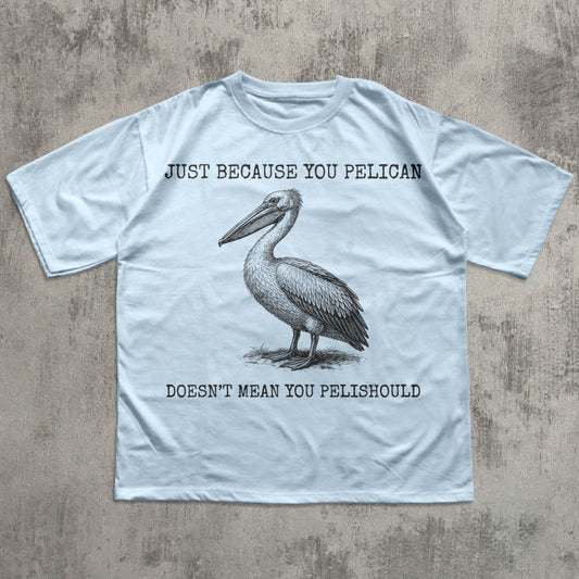 Light blue t-shirt with a pelican graphic and humorous text on a textured surface