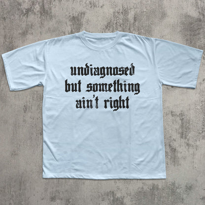 Light blue t-shirt with black text on a textured gray background