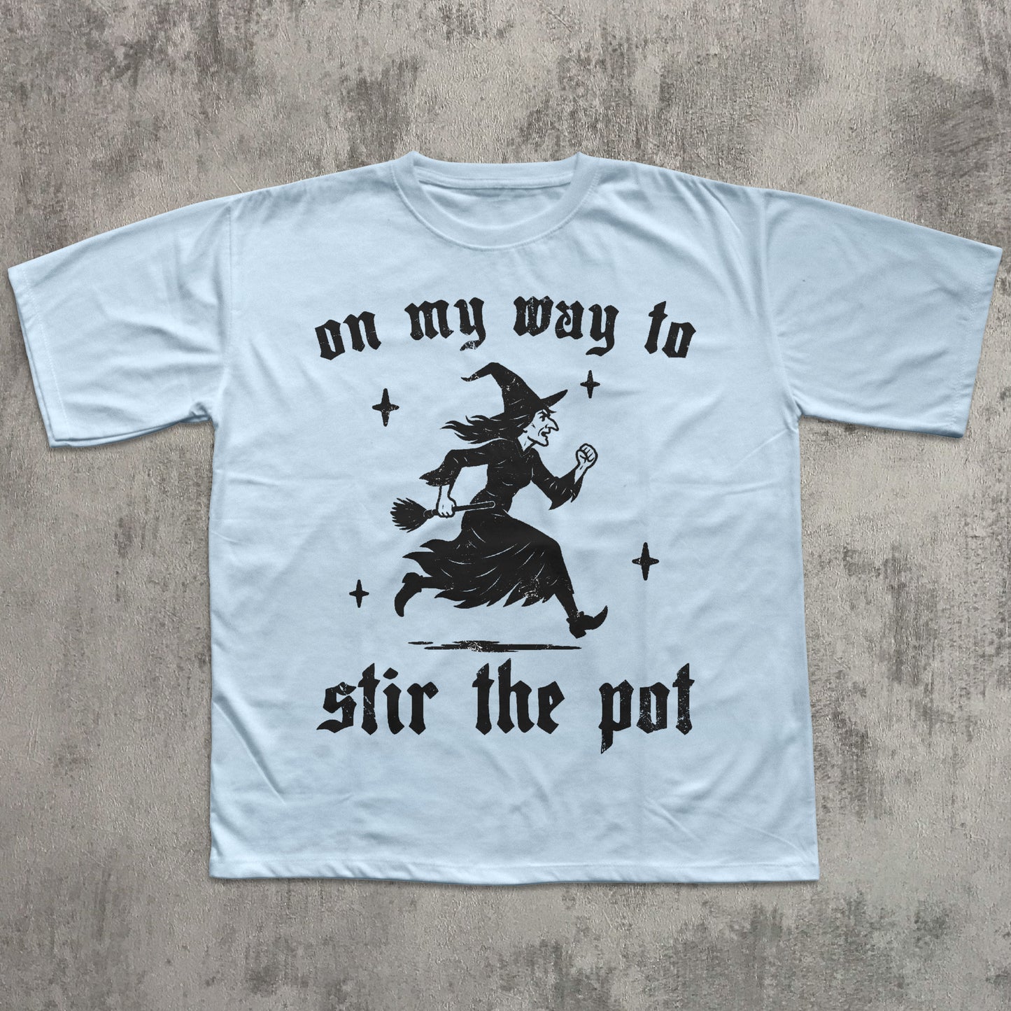 Light blue t-shirt with black graphic and text on a textured gray background
