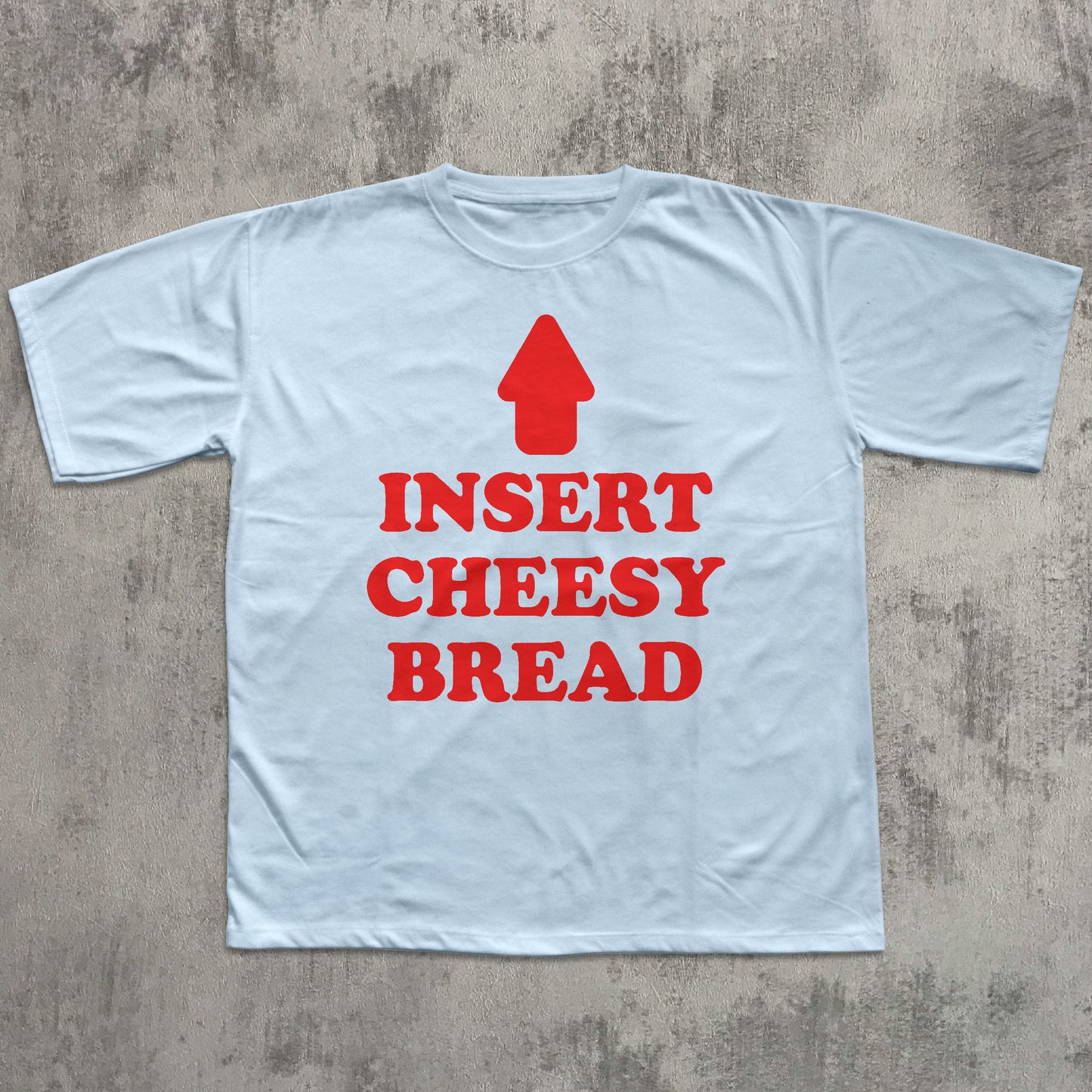 Light blue t-shirt with red text and an arrow graphic on a concrete surface