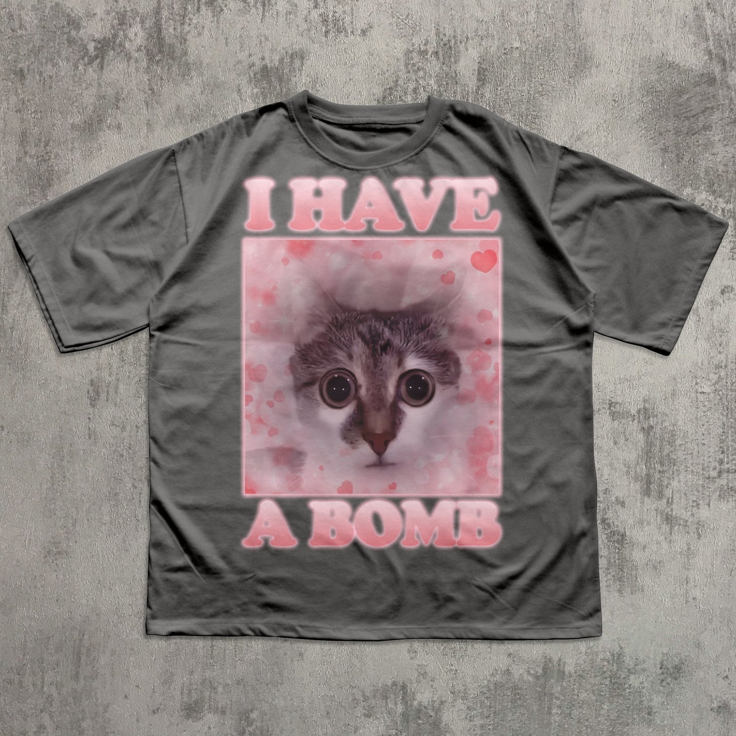 Gray t-shirt with a graphic of a cat and text 'I HAVE A BOMB' on a textured gray background