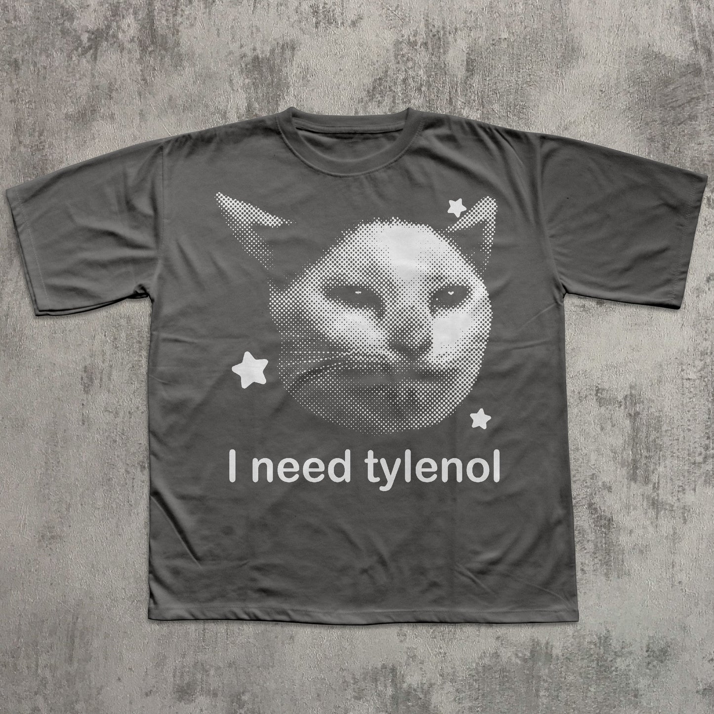 Gray t-shirt with a cat graphic and 'I need tylenol' text on a textured gray background