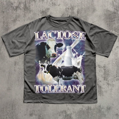 Funny Gray t-shirt with a graphic of cows and milk, and the text 'LACTOSE TOLERANT' on a concrete background.