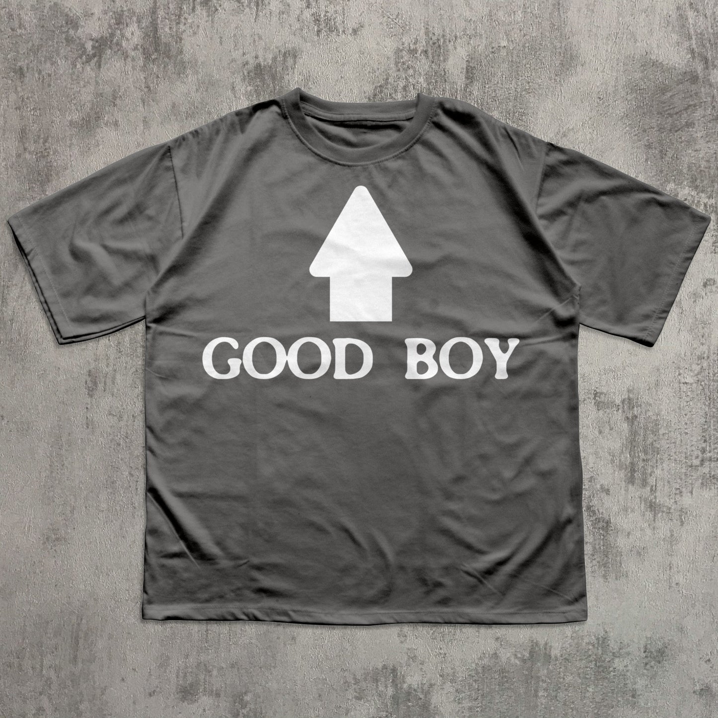 Gray t-shirt with 'GOOD BOY' text and white arrow graphic on a textured gray background