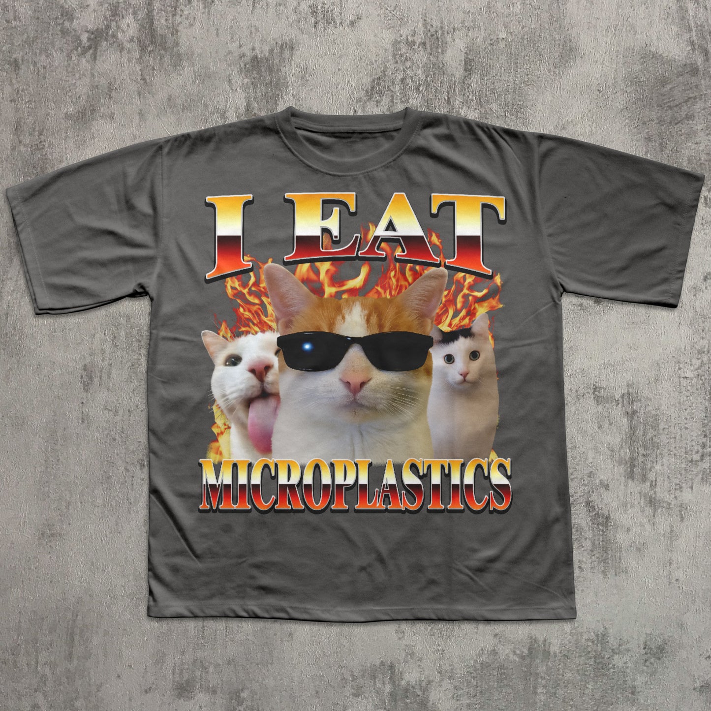 Gray t-shirt with a graphic of cats and text 'I Eat Microplastics' on a textured gray background