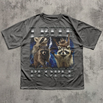 Gray t-shirt with raccoon graphic and text 'I BITE PEOPLE' on a textured gray background
