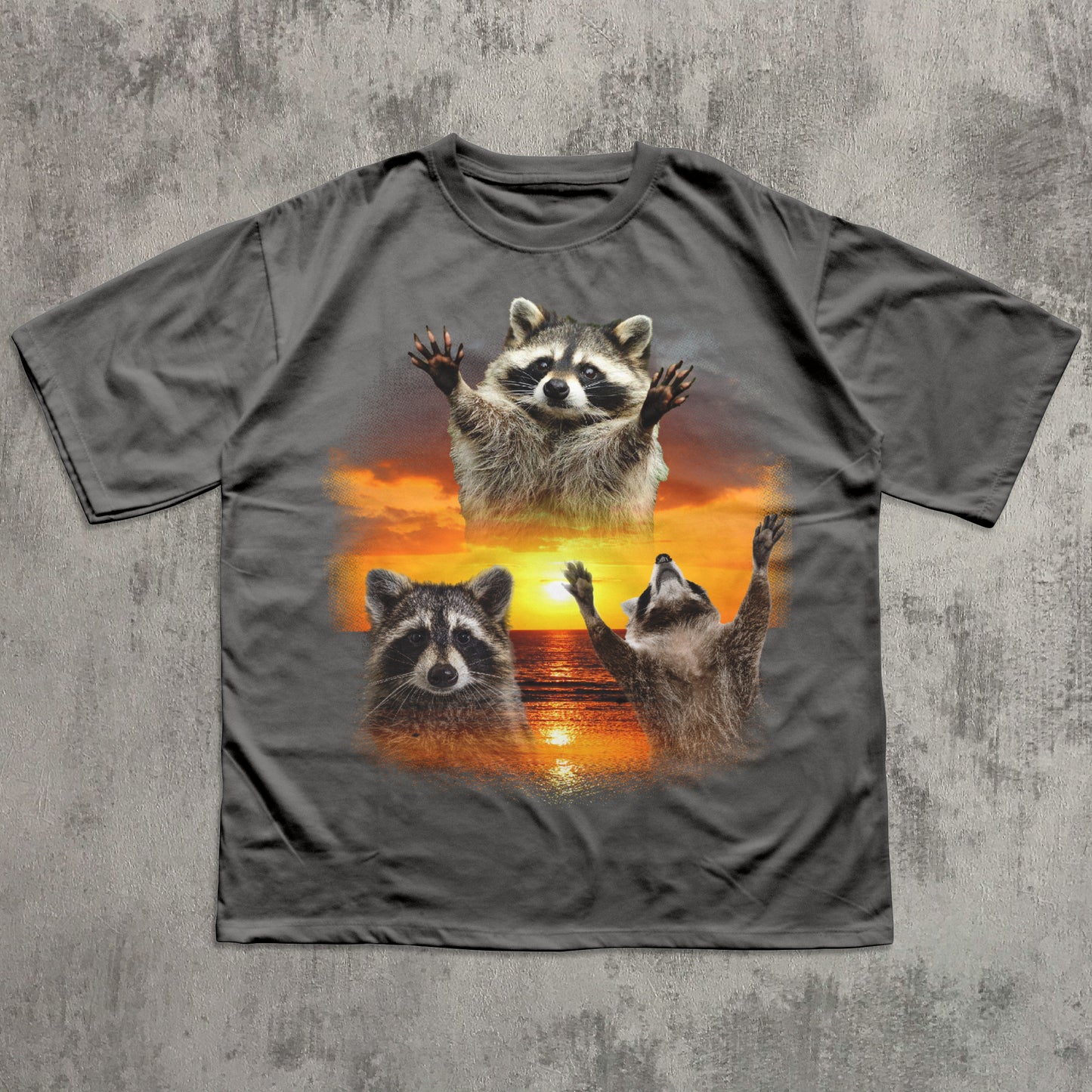 Gray t-shirt with raccoon design on a textured gray background