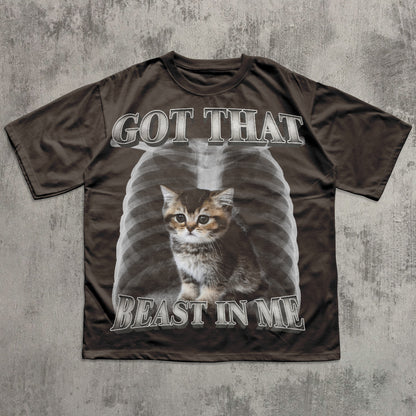Brown t-shirt with a graphic of a cat and text 'GOT THAT BEAST IN ME' on a textured gray background