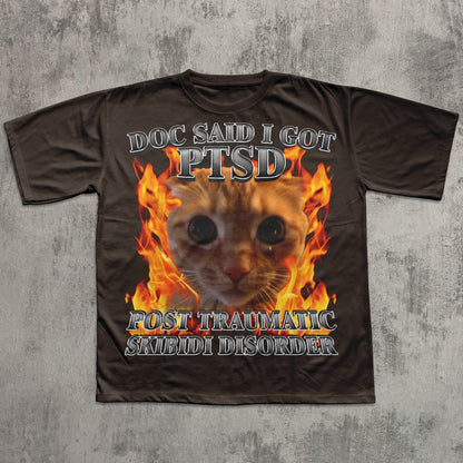 Brown t-shirt with a cat graphic and text on a textured gray background