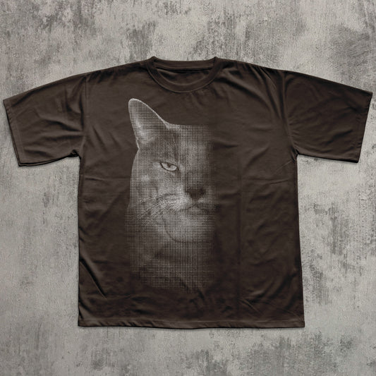 Brown t-shirt with a graphic of a cat's face on a textured gray background