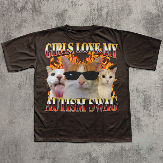 Brown t-shirt with cat graphic and text 'Girls love my autism swag' on a textured gray background