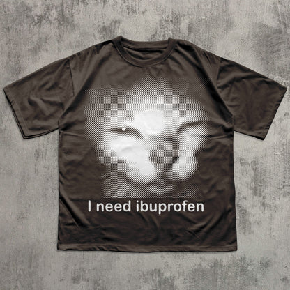 Brown t-shirt with a graphic of a face and 'I need ibuprofen' text on a textured gray background